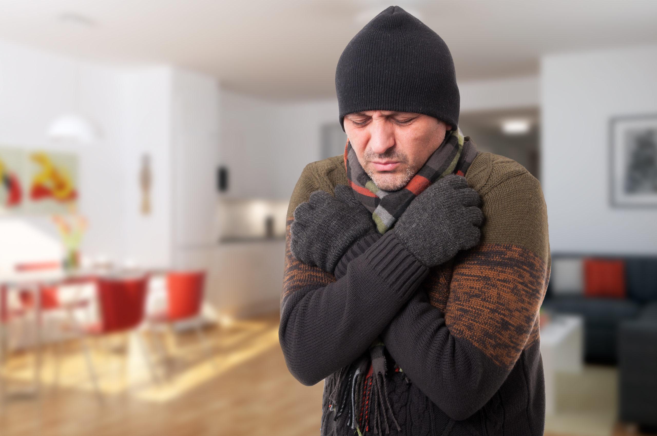 man shivering inside of cold house